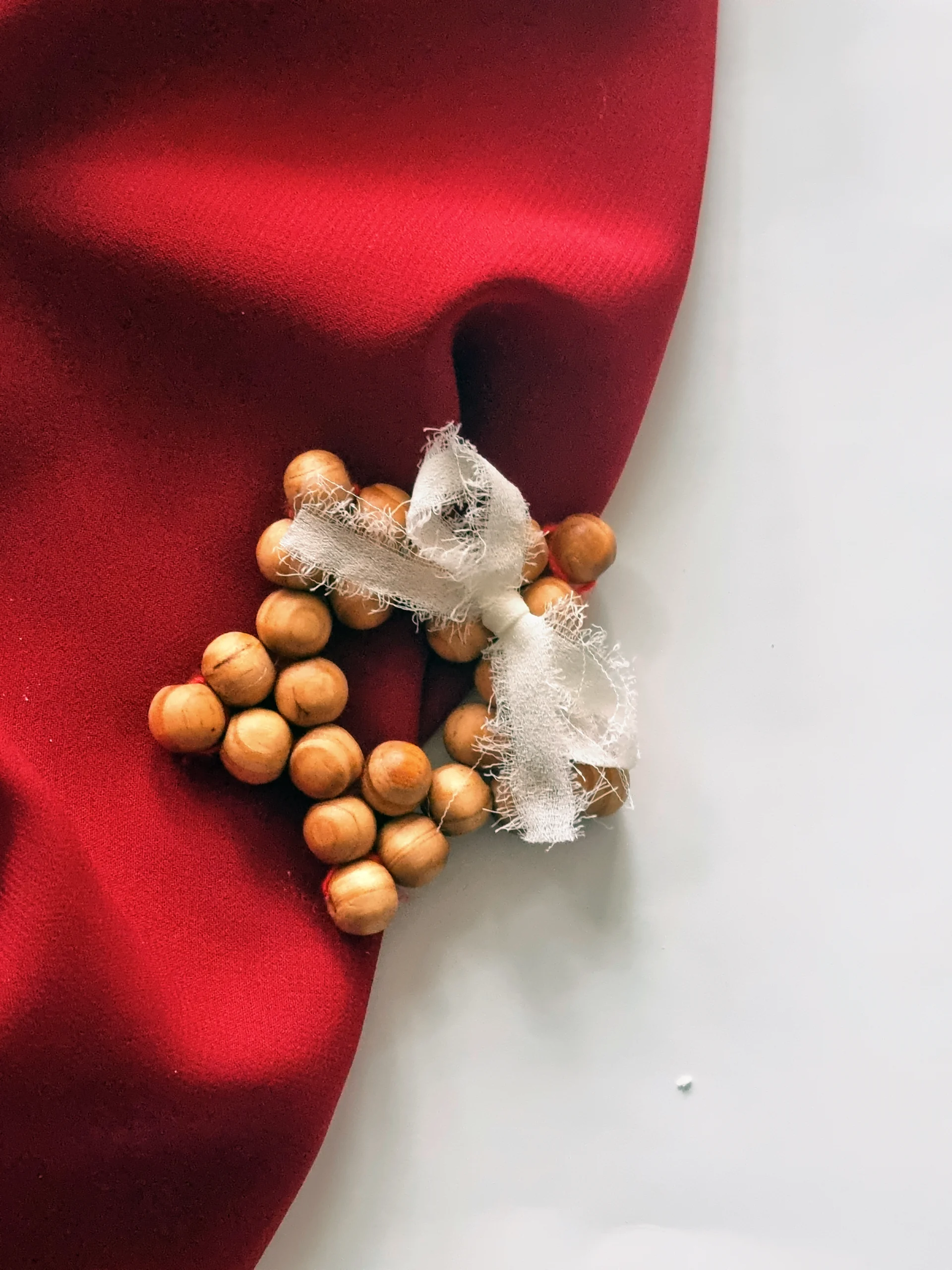 Ręcznie wykonana zawieszka z drewnianych koralików i szyfonowej kokardy to minimalistyczna, ekologiczna dekoracja, idealna na choinkę i świąteczne aranżacje.